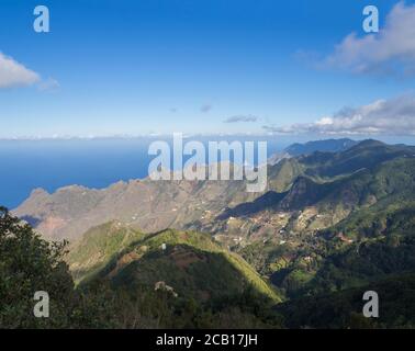 Aussichtspunkt Amogoje, grüne Hügel mit Felsen im Meer El Draguillo in anaga Berg, teneriffa kanarische Insel spanien mit dramatischen blauen Himmel weißen Wolken Stockfoto