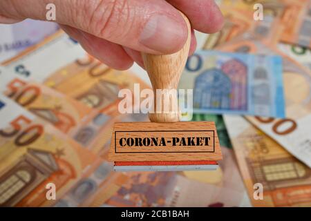 FOTOMONTAGE, symbolisches Bild des Konjunkturpakets während der Corona-Krise, Stempel mit Aufschrift CORONA-PAKET, Deutschland Stockfoto