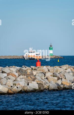 Sassnitz Mukran, Deutschland. August 2020. Der Offshore-Lieferant 'World Bora' betritt den Hafen. Ein kleiner Leuchtturm, ein achteckiger und 14 Meter hoher Betonturm, wurde 1995 auf dem Kopf der Hafenmole am Hafeneingang errichtet. Quelle: Stephan Schulz/dpa-Zentralbild/ZB/dpa/Alamy Live News Stockfoto