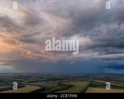 Regenwolken über grünen Feldern und Seen. Luftaufnahme. Stockfoto