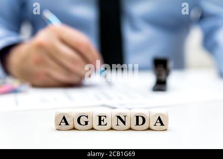 Geschäftsmann im Büro, dices mit Wort Agenda, Planung und Auftrag Programm und Strategie Stockfoto