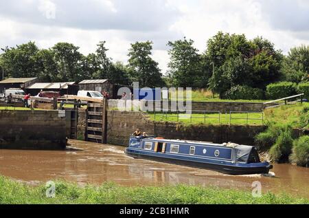 Ein schmales Boot mit blauem Kanal „Sapphire“, das die Tarleton Sea Lock verlässt, stößt gegen die ankommende Flut, während es die Ribble Link überquert. Stockfoto