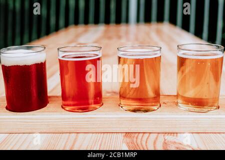 Bierprobe. Diferent Bier in 100 Mililiter Brille über Holztisch. Stockfoto