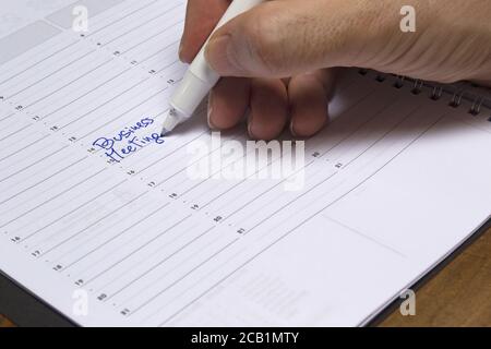 Planung der Meeting-Zeit auf einem Notizblock, um ein Business-Meeting zu beheben. Konzept für Unternehmen, Job-Anwendungen Stockfoto