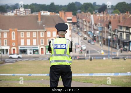 Polizist steht Wache an der Absperrung am Tatort mit Blick auf Englisch Stadt Stockfoto