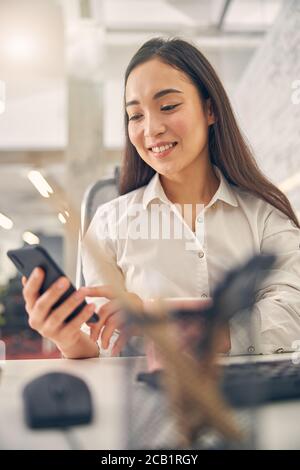 Fröhliche Brünette weibliche Person zeigt ihr Lächeln Stockfoto