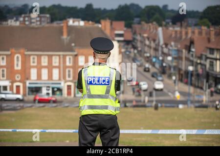 Polizist steht Wache an der Absperrung am Tatort mit Blick auf Englisch Stadt Stockfoto