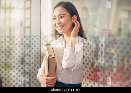 Charmante internationale weibliche Person im Büro Stockfoto