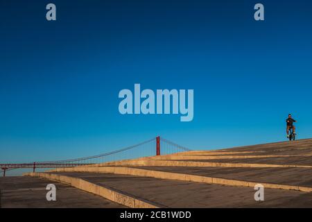 Eine Person auf dem Fahrrad genießt den Sonnenuntergang auf der Dachterrasse des MAAT, dem Museum für Kunst, Architektur und Technologie. Stockfoto