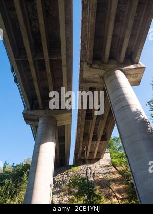 Multiple Lane Highway Brücke mit Stahlbetonsäulen von unten betrachtet. Blauer Himmel Hintergrund Stockfoto