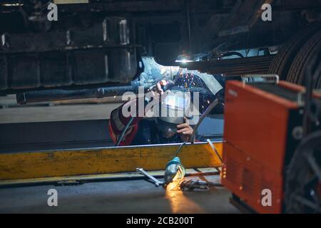 Nahaufnahme von seriösen Menschen, die Metallteile schweißen Stockfoto