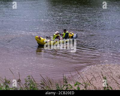 Frau und Mann kommen nach dem Ausflug entlang des Flusses an Land Wye in einem Explorer KS Schlauchboot Ross-on-Wye Herefordshire England VEREINIGTES KÖNIGREICH Stockfoto