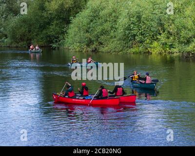 Eine Familiengruppe und ein Vater und ein Sohn paddeln Mad Flusskanus, die einander auf dem Fluss Wye Symonds Yat passieren West Herefordshire England Großbritannien Stockfoto