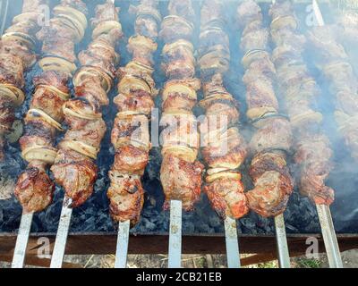 Kebab. Nahaufnahme von gegrillten Schweinespiessen auf dem Grill in Rauch. Stücke von saftigem Schweinefleisch auf einem Spieß aufgereiht Stockfoto