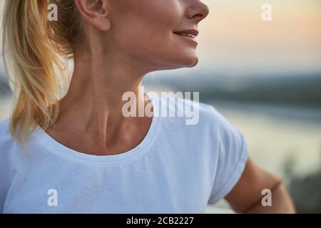 Frau mit einem erfreuenden Lächeln im Freien stehend Stockfoto