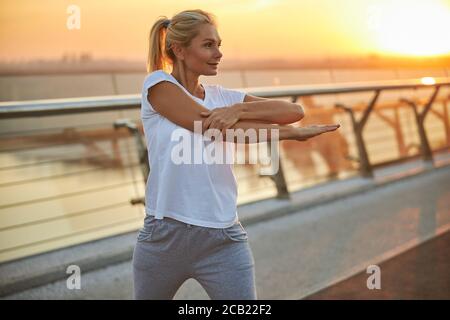 Frau in Sportbekleidung macht eine Aufwärm-Übung Stockfoto
