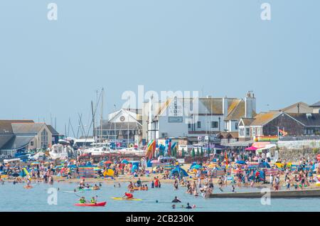 Lyme Regis, Dorset, Großbritannien. August 2020. UK Wetter: Urlauber, Familien und Strandgänger sonnen sich in der heißen und nebeligen Sonne am Strand im Badeort Lyme Regis am letzten sonnigen Tag, bevor Gewitter und Regen später in der Woche eintreffen. Kredit: Celia McMahon/Alamy Live Nachrichten Stockfoto