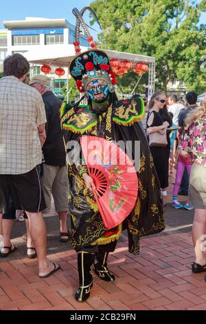 Ein chinesischer "Face Changing" (Bian lian) Performer in Maske und schwarzer Drachenrobe während der chinesischen Neujahrsfeiern. Hamilton, Neuseeland, 16/2019 Stockfoto