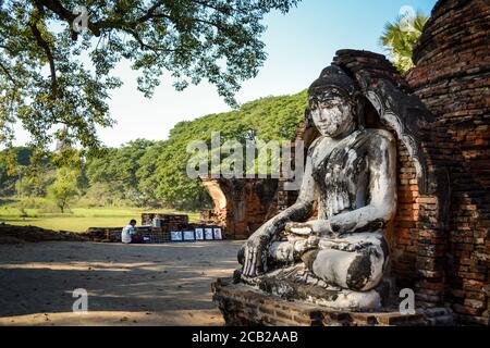 Inwa, oder Ava, Mandalay, Myanmar, Südostasien - die Statue des Buddha in Yadana Hsimi Pagodas und der Maler, der seine Bilder verkauft. Stockfoto