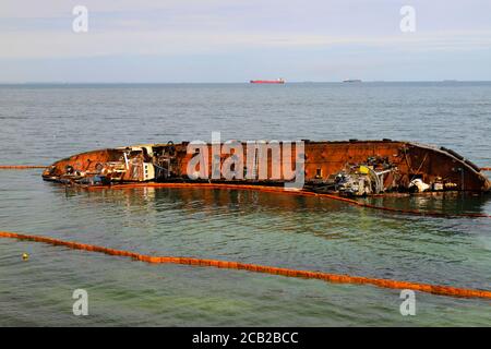 Ein alter rostiger Tanker überflutet und liegt in der Nähe der Küste in Odessa, Ukraine. Öl wird aus dem Schiff verschüttet und verschmutzt das Meerwasser. Umweltverschmutzung Stockfoto