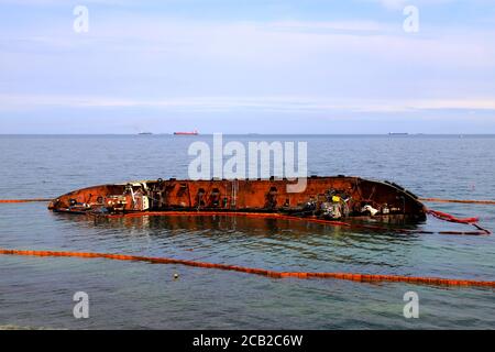 Ein alter rostiger Tanker überflutet und liegt in der Nähe der Küste in Odessa, Ukraine. Öl wird aus dem Schiff verschüttet und verschmutzt das Meerwasser. Umweltverschmutzung Stockfoto