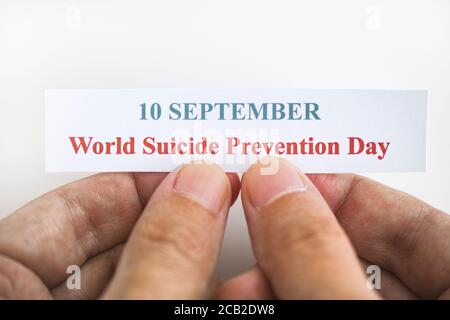 Person, die ein Stück Papier mit den Worten World Suicide Prevention Day (September 10) hält. Nahaufnahme. Stockfoto