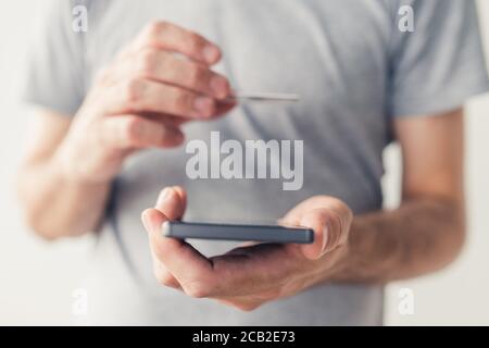 Mobile Banking, Mann mit Kreditkarte und Smartphone-App online kaufen oder Rechnungen bezahlen Stockfoto