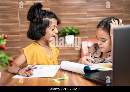 Zwei Kinder Geschwister beschäftigt im Gespräch während e-Learning oder online Klasse - Konzept der Heimschulung oder Remote-Klassenzimmer zu Hause Während covid-19 oder Stockfoto