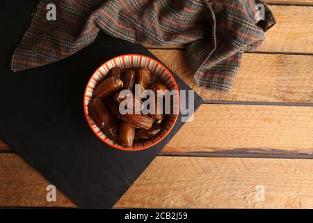 Aufnahme von medjool Dates in einer Schüssel auf einem Küchentisch aus Holz Stockfoto