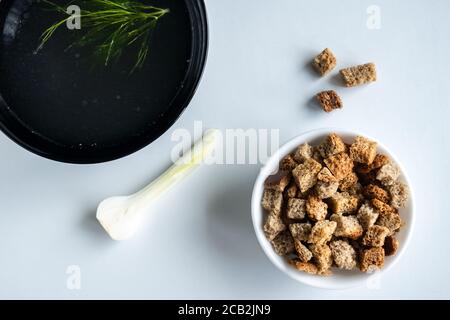 Hausgemachte Fleischknochenbrühe in einer Schüssel mit Dill, Zwiebeln und Croutons. Auf weißem Hintergrund. Gesunde Ernährung Konzept. Paleo Diät. Nahaufnahme. Selektiver Fokus. Stockfoto