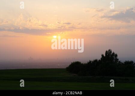 Sonnenuntergang über Manchester City vom Werneth Low Golfplatz. Die schlechte Sicht der Luft und die Wolken trugen zu einem spektakulären tieforange roten Sonnenuntergang bei. VEREINIGTES KÖNIGREICH Stockfoto