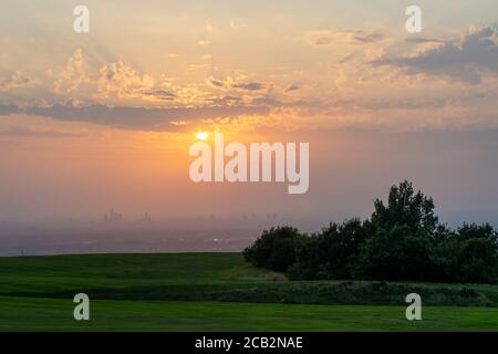 Sonnenuntergang über Manchester City vom Werneth Low Golfplatz. Die schlechte Sicht der Luft und die Wolken trugen zu einem spektakulären tieforange roten Sonnenuntergang bei. VEREINIGTES KÖNIGREICH Stockfoto