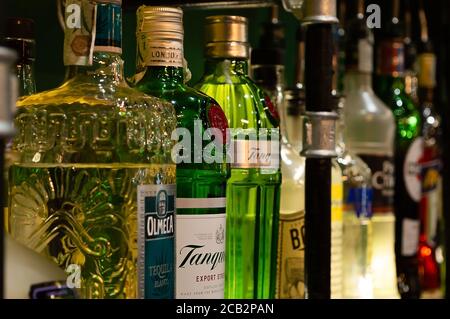 Mehrere farbige Alkoholflaschen auf einem Regal in einem Pub Stockfoto