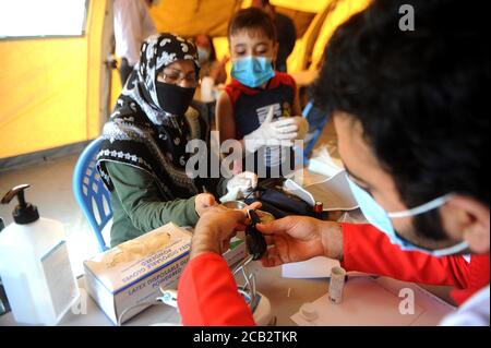 Beirut, Libanon. August 2020. Ein Arzt behandelt am 10. August 2020 einen Patienten im Iran-unterstützten Feldlazarett in Beirut, Libanon. Libanon hat in den letzten Tagen Feldkrankenhäuser aus einer Reihe von Ländern erhalten. Quelle: Bilal Jawich/Xinhua/Alamy Live News Stockfoto