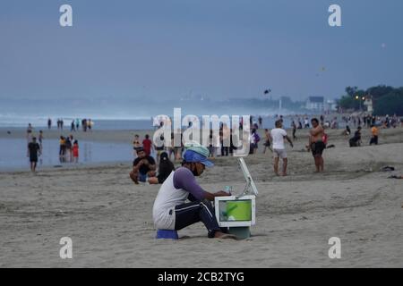 10. August 2020, Badung, Bali, Indonesien: Ein Straßenhändler pedlelt sein Produkt am Strand. Die Menschen genießen ihren Urlaub am Legian Beach inmitten des Covid-19 Coronavirus-Ausbruchs, als Bali für den indonesischen Inlandstourismus am 31. Juli 2020 wiedereröffnet wurde. Zeitplan der lokalen Behörden zur Eröffnung des internationalen Tourismus am 11. September 2020. (Bild: © Dicky Bisinglasi/ZUMA Wire) Stockfoto