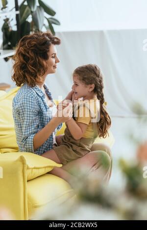 Selektiver Fokus von liebenswert Kind sitzt auf Runden des Lächelns nanny Stockfoto