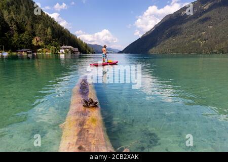 Kaukasische junge auf Paddleboard auf See Stockfoto