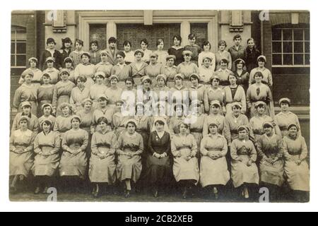 Originalpostkarte aus der Zeit WW1 mit weiblichen Krankenhauskriegsarbeitern, jungen Frauen, die Uniformen und Mützen tragen, eine Matrone sitzt in der ersten Reihe, möglicherweise Krankenhauskorderlies in Großbritannien um 1916 Stockfoto