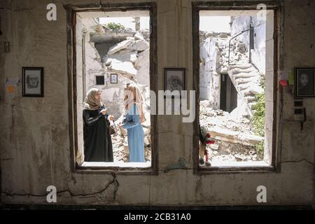 Idlib City, Syrien. August 2020. Besucher besichtigen eine Ausstellung des syrischen Künstlers Rami Abd al-Haq in einem der beschädigten Häuser in Idlib. Die Zeichnungen zeigen Figuren und Figuren, die während des syrischen Bürgerkriegs entstanden sind und Einfluss auf die Medien hatten. Quelle: Anas Alkharboutli/dpa/Alamy Live News Stockfoto