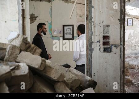 Idlib City, Syrien. August 2020. Besucher besichtigen eine Ausstellung des syrischen Künstlers Rami Abd al-Haq in einem der beschädigten Häuser in Idlib. Die Zeichnungen zeigen Figuren und Figuren, die während des syrischen Bürgerkriegs entstanden sind und Einfluss auf die Medien hatten. Quelle: Anas Alkharboutli/dpa/Alamy Live News Stockfoto