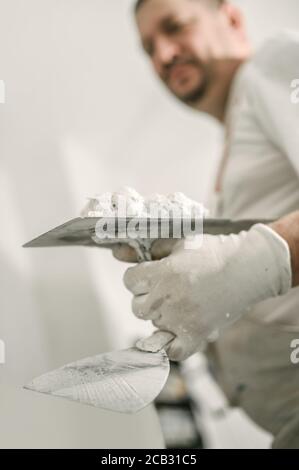 Bauarbeiter mit Spachtel und Mörtel. Bauwerkzeuge Stockfoto