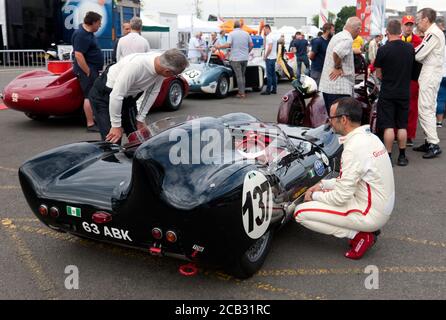 Max Girardo im Gespräch mit Peter Haynes, im Cockpit seines 1959 Lotus XI Le Mans, wartet auf das Qualifying der RAC Woodcote Trophy. Stockfoto