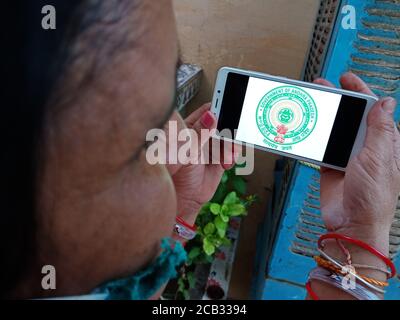 DISTRIKT KATNI, INDIEN - 23. MAI 2020: Frau hält Smartphone mit ausgestellten Regierung von andhra pradesh Symbol auf dem Bildschirm. Stockfoto