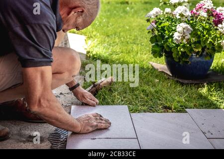 Flieseninstallation mit Kleber auf Betonboden Stockfoto