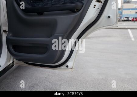Nahaufnahme der offenen Tür eines weißen Autos mit einem schwarzen Panel im Innenraum mit Stoff nach der Trockenreinigung fertig In einem Autoservice vor dem Hintergrund o Stockfoto
