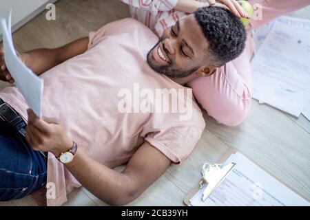 7/8 Schuß eines jungen afrikanischen amerikanischen Paar Fernsehen zu Hause. Stockfoto