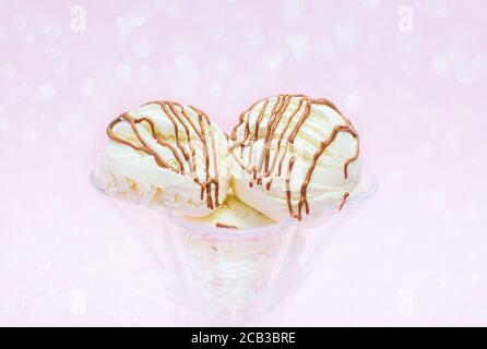 Eiskugeln mit Schokolade auf rosa Hintergrund mit Bokeh. Sommerzeit Stockfoto