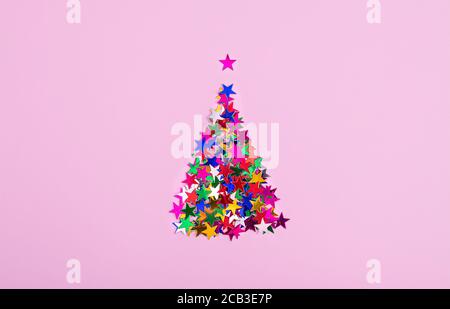 Ein weihnachtsbaum aus bunten Sternen auf einem rosa Hintergrund. Weihnachtsverkäufe Stockfoto