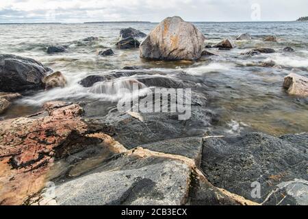 Wellenreiten auf Granitfelsen entlang des Lake Superior in Katherine Cove, Lake Superior Provincial Park, Ontario, Kanada Stockfoto