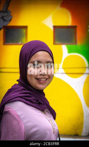 Kuala Lumpur/Malaysia/24 May 2020: Junge schöne muslimische Mädchen mit einem lila Kopftuch und einem rosa Kleid in Jalan Alor, Malaysia Stockfoto